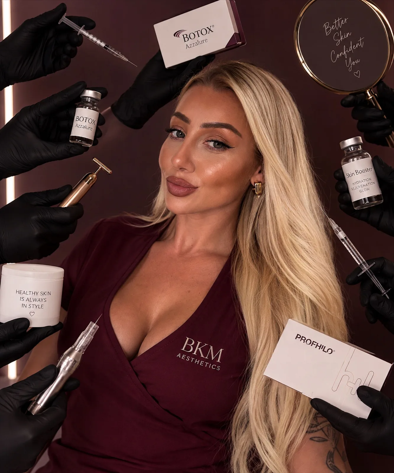 Jessica, Buckingham Aesthetics practitioner, wearing burgundy scrubs and pictured among aesthetic treatment products and equipment
